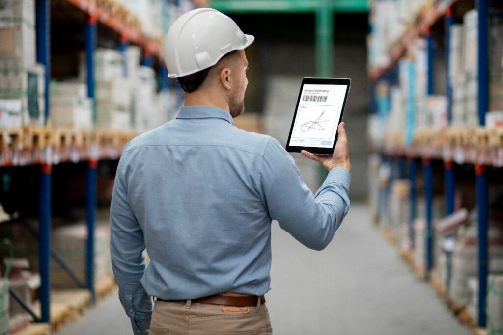 homem vendo gráficos em um tablet dentro do depósito