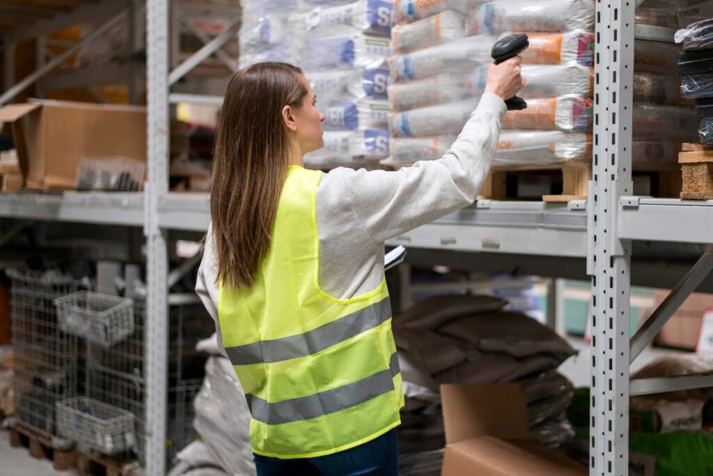 funcionária lendo cógido de barras de produto em depósito