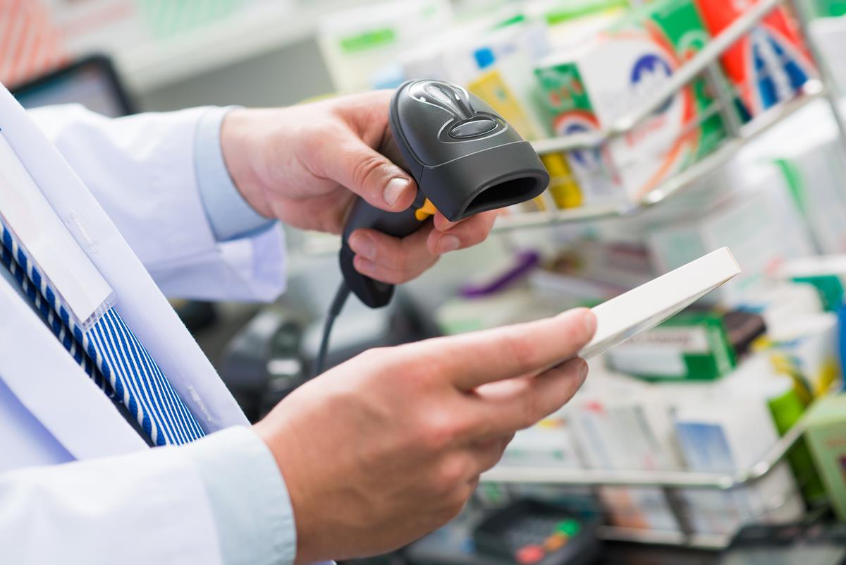 mãos masculina segurando uma máquina fazendo leitura de codigo de barras